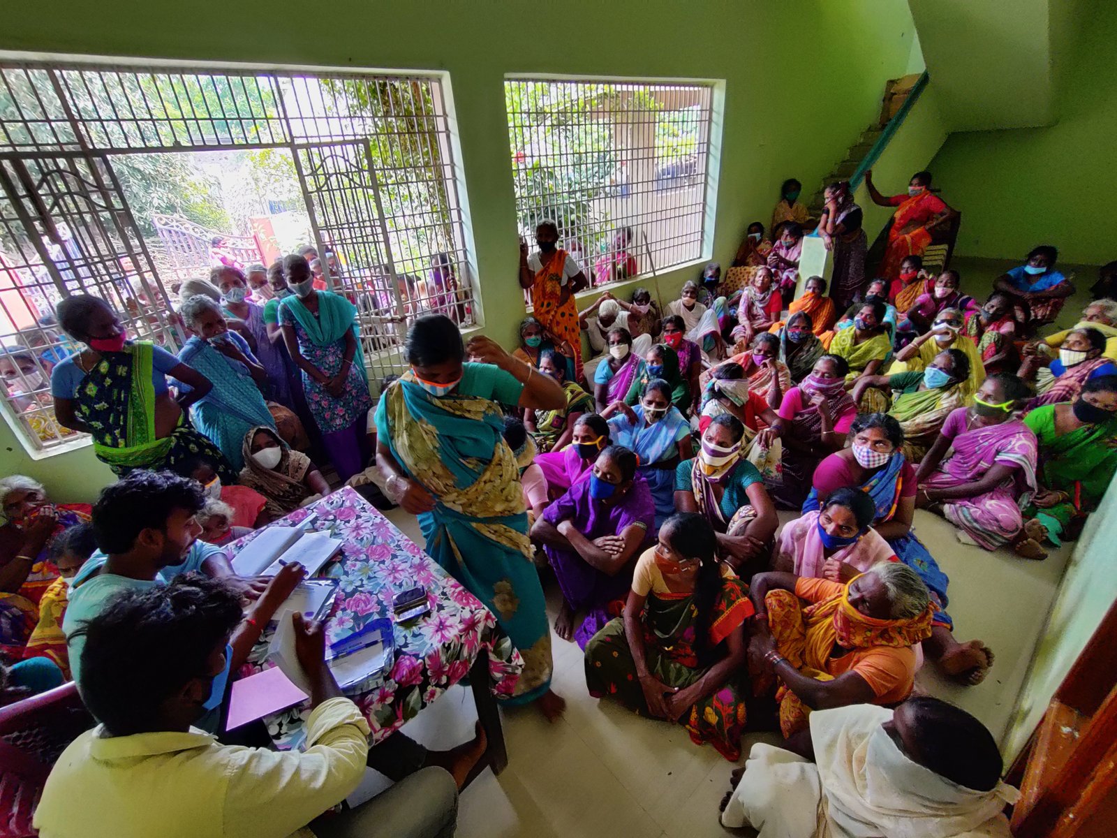 A hall packed with widows seated on the floor at a Bethel Mission gathering, some with young children